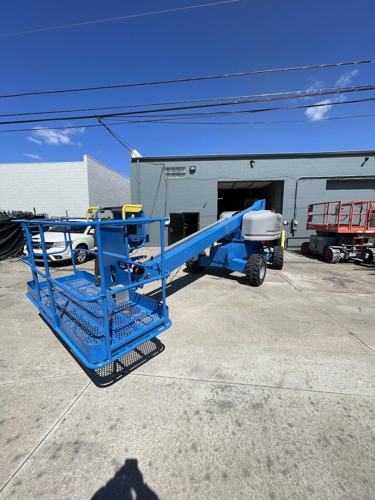 Freshly painted blue boom lift outside after industrial equipment repaint