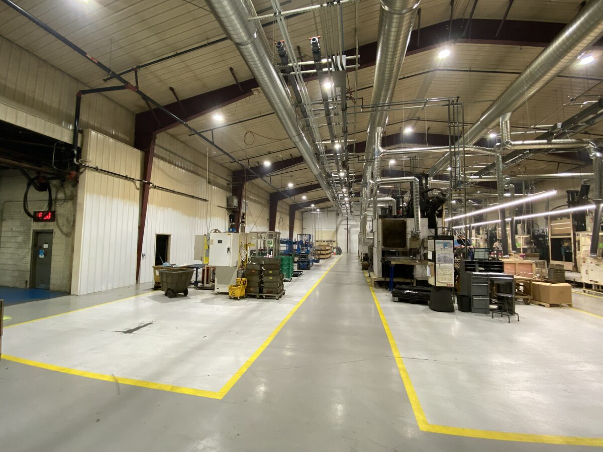 Operating industrial factory floor with freshly painted floor markings and active machinery