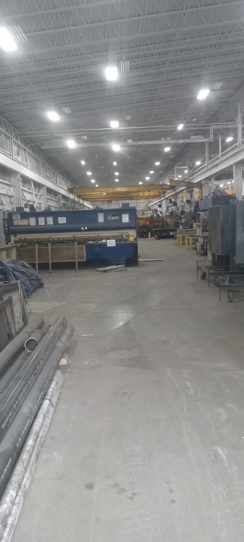 Long view down the repainted AFC Holcroft shop bay with white deck ceiling, overhead crane, and production equipment