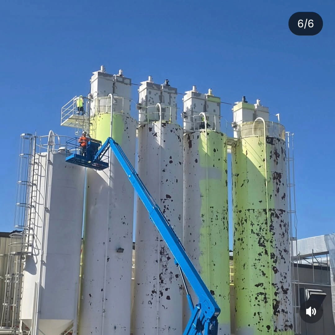Storage tank at chemical facility — repainted exterior with valves and fittings masked