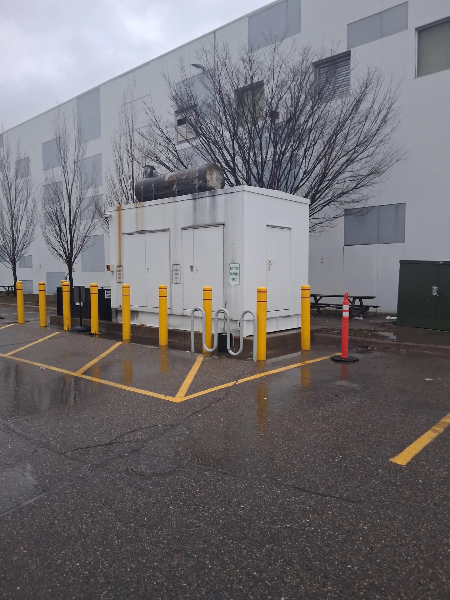 Generator enclosure before service — exhaust staining and a rusted rooftop fuel tank
