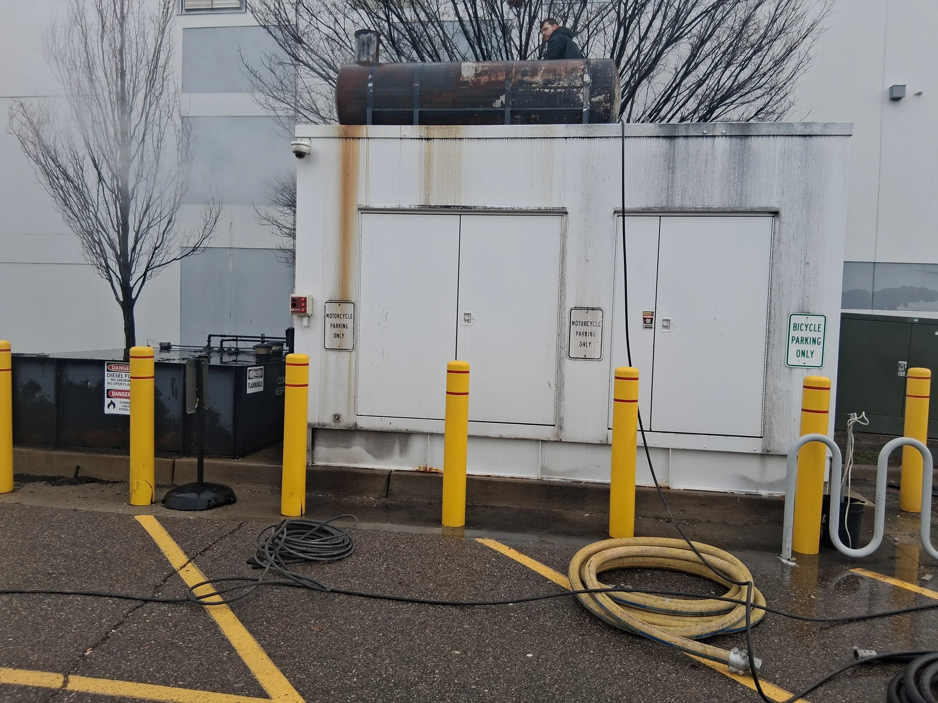 Crew working on the rusted rooftop fuel tank before surface prep