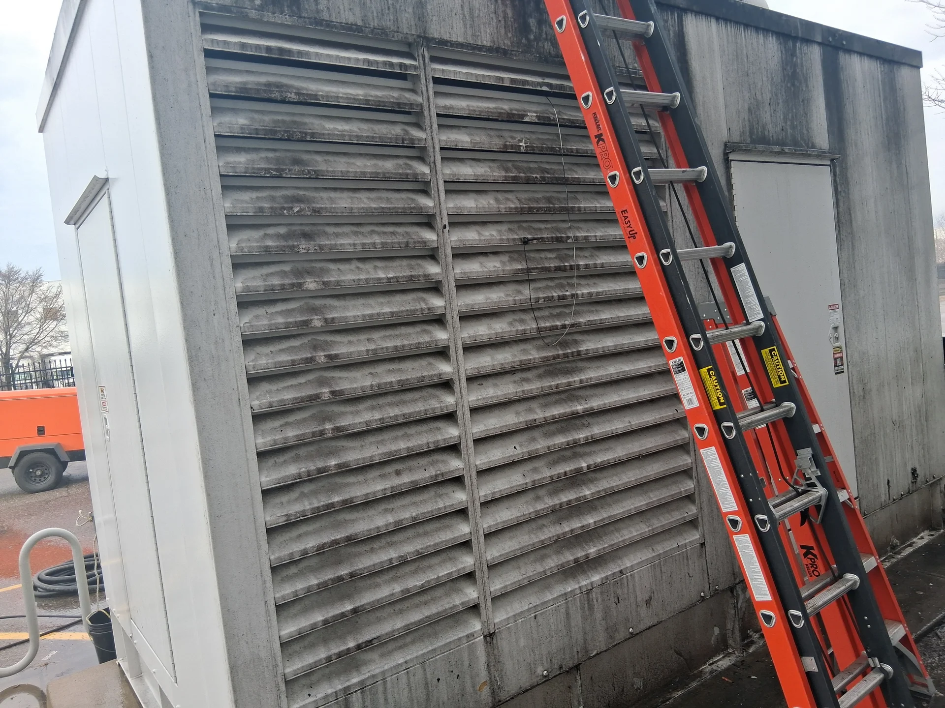 Generator enclosure louvers before cleaning, coated in exhaust soot and grime