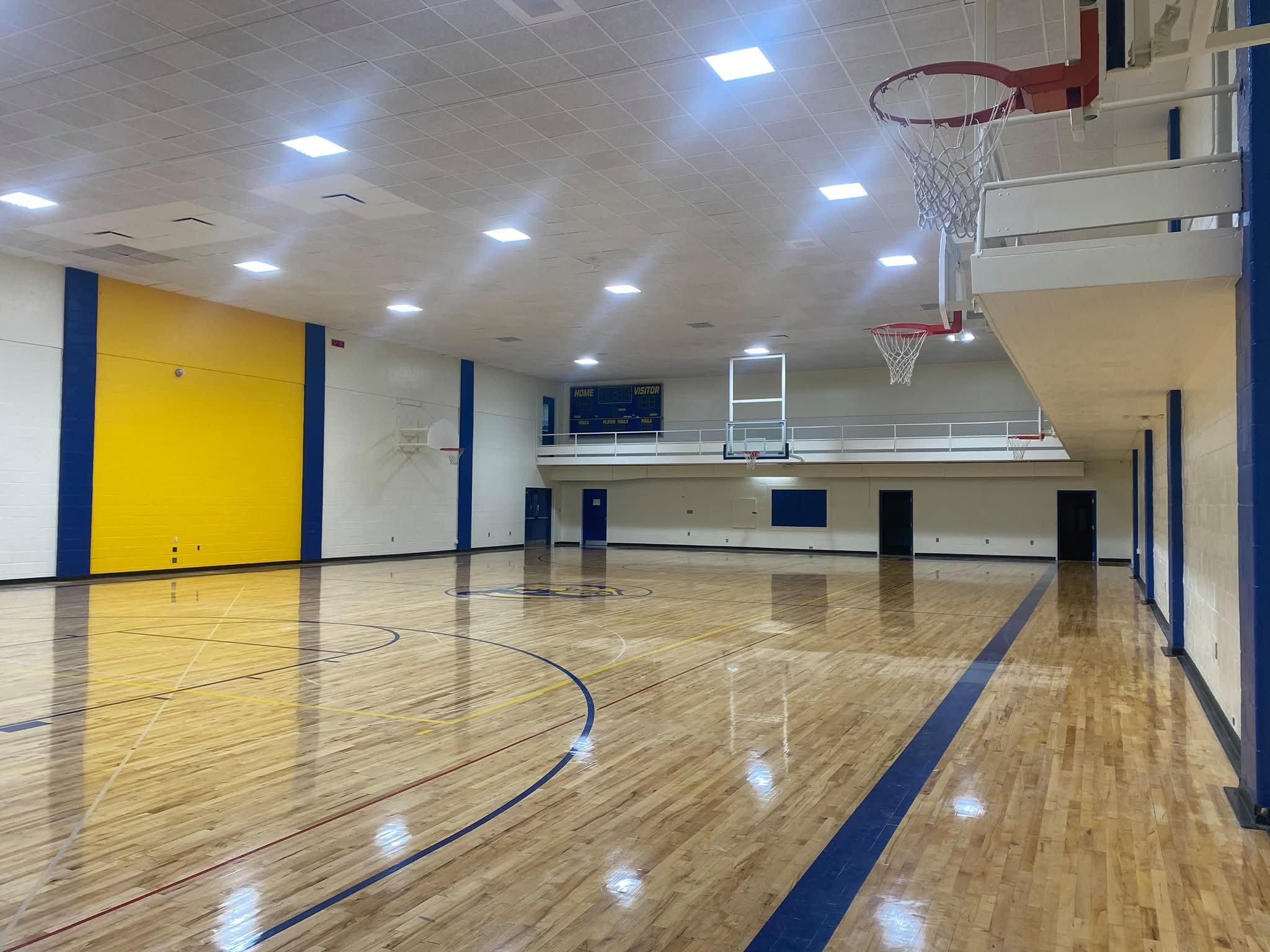 Gymnasium opposite end — full court and blue accent stripes
