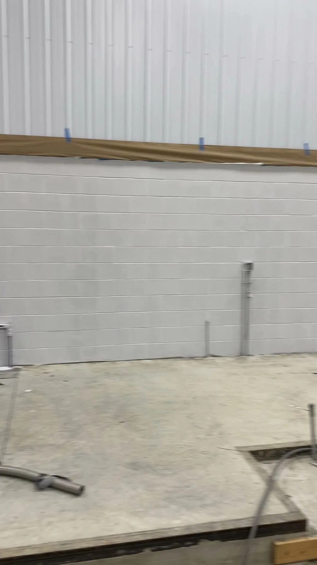 Finished CMU block wall after block fill — smooth uniform surface sealed and ready for paint in new construction facility