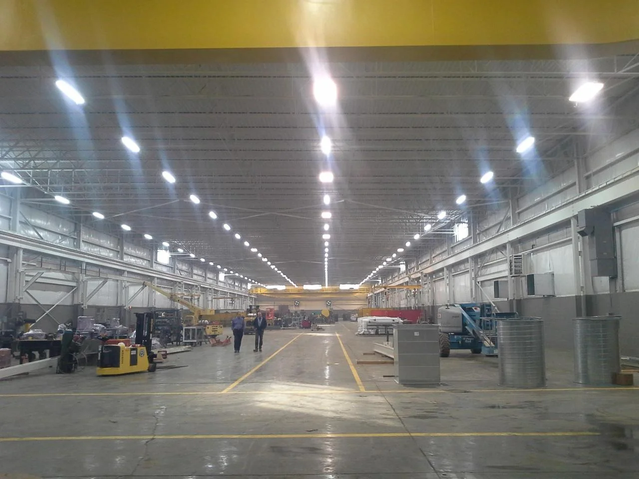 Central Conveyor manufacturing facility interior with freshly painted white walls, yellow accent beam, and overhead crane