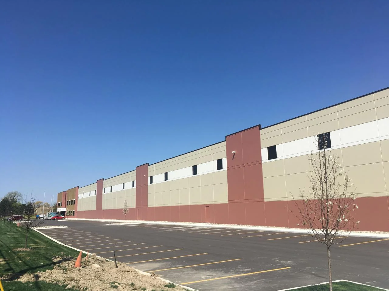 CMAC Trucking building exterior with freshly painted tan and maroon color-blocked panel walls