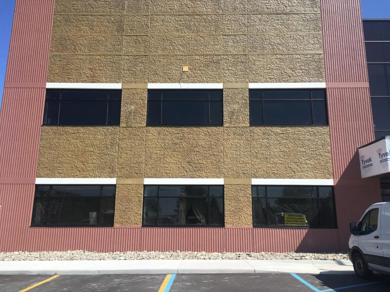 Close-up of the faux brick finish accent wall with maroon corrugated trim and black window frames