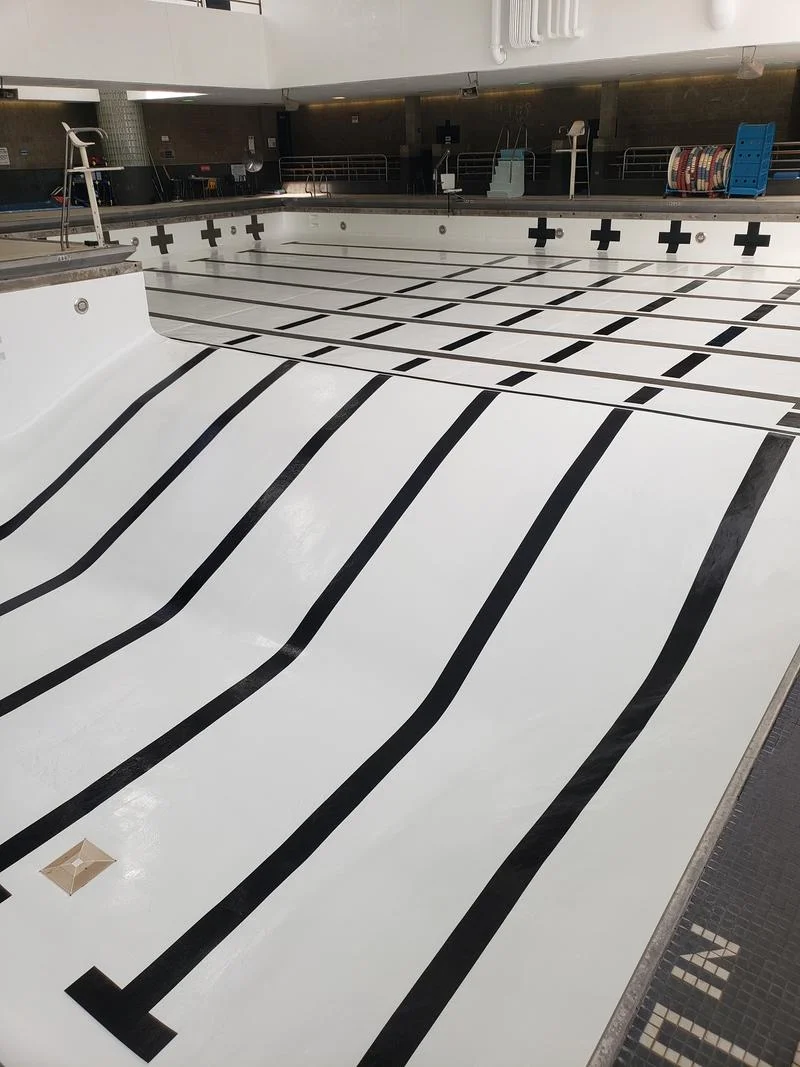 Finished pool floor with crisp white coating and black lane stripes