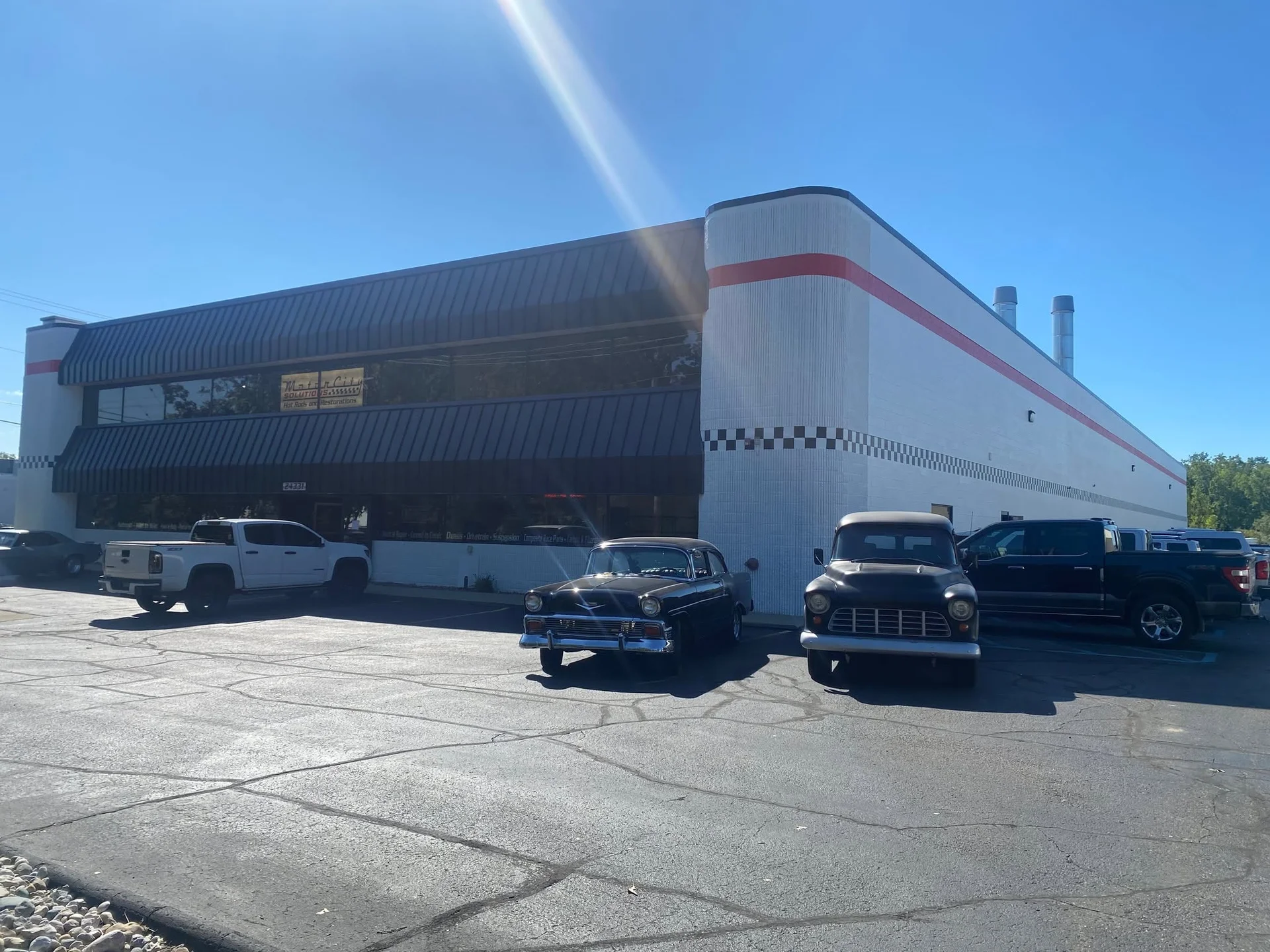 Commercial building exterior with freshly painted white block walls and red accent stripe