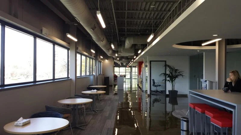 Open office workspace with freshly painted walls, seating area, and red accent stools