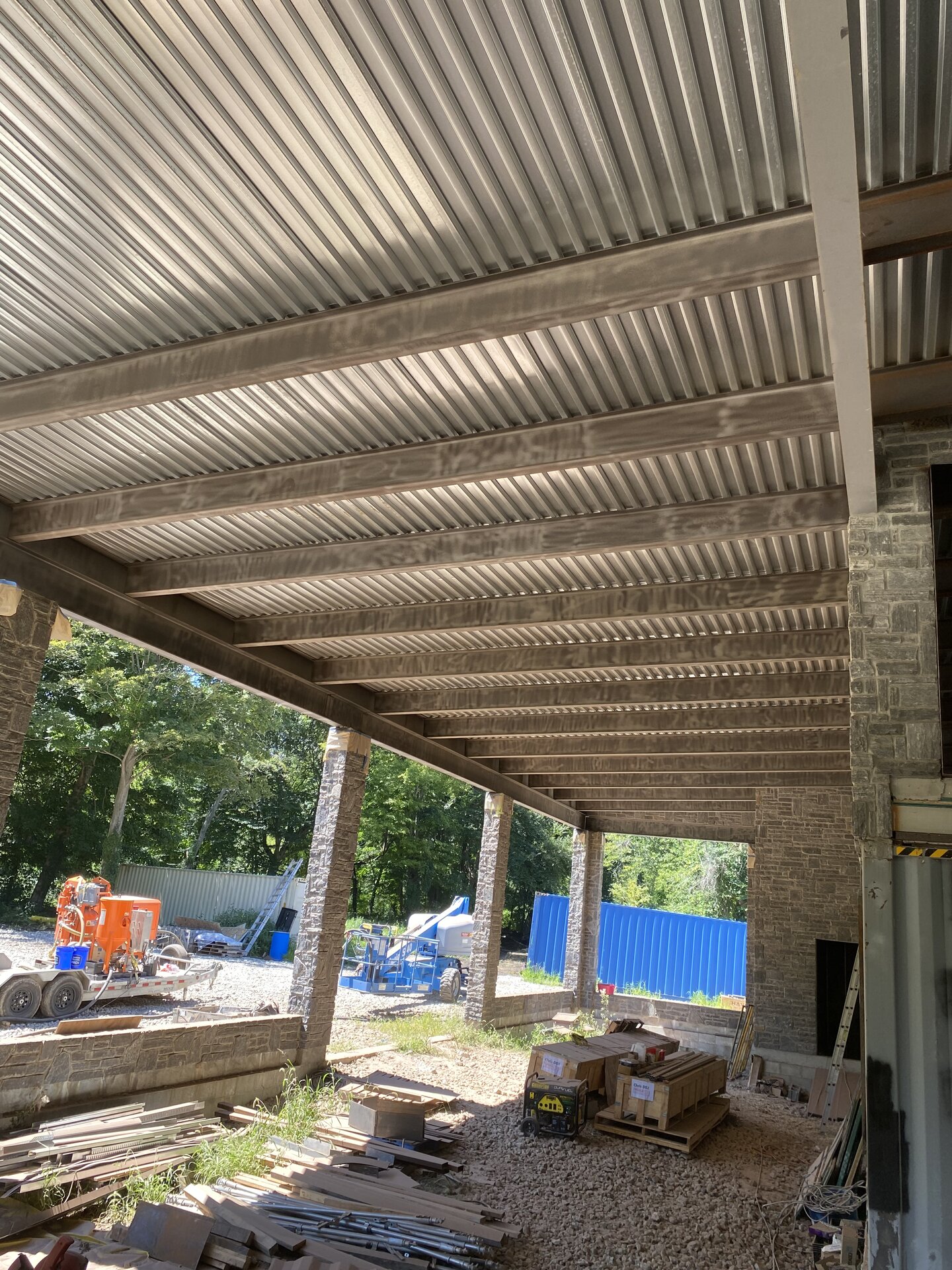 Roof deck underside before painting — raw steel and corrugated panels