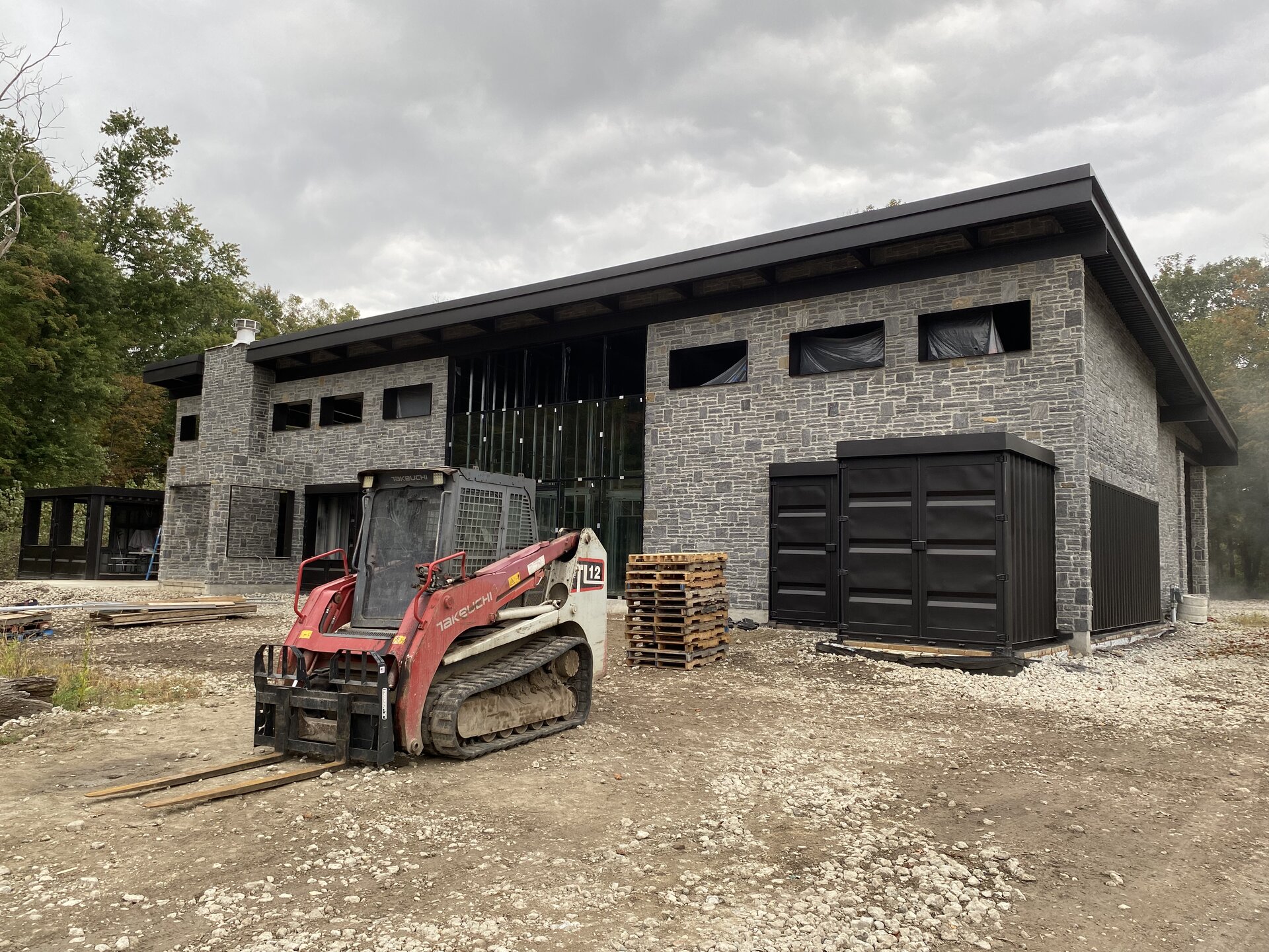 Container house exterior with finished black containers and painted structural steel