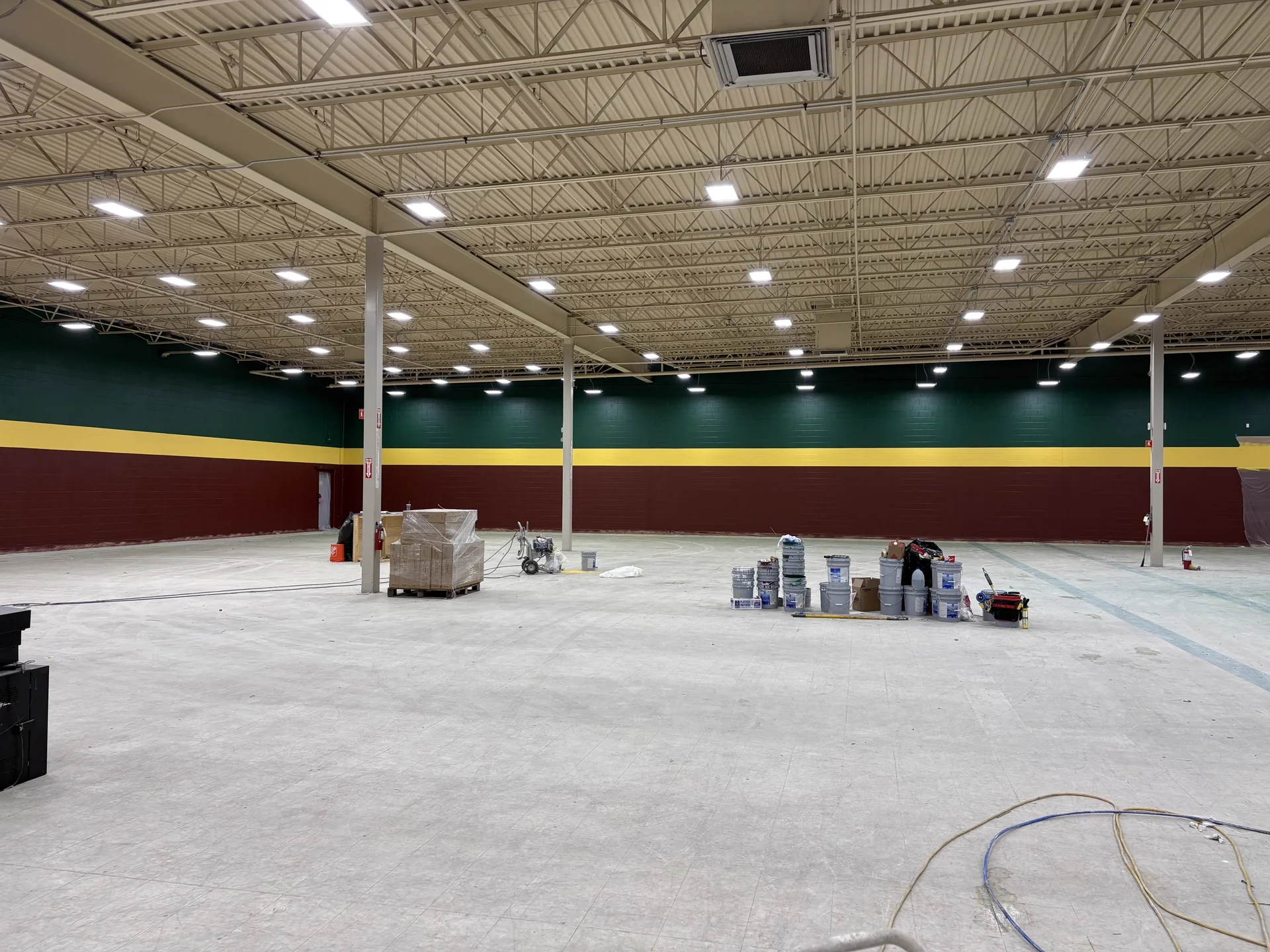 D-Bat Batting Cages interior — green, maroon, and gold stripe commercial wall painting
