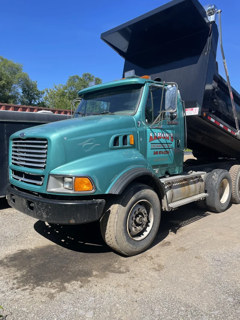 Before — the same Sterling dump truck cab in its original faded teal paint