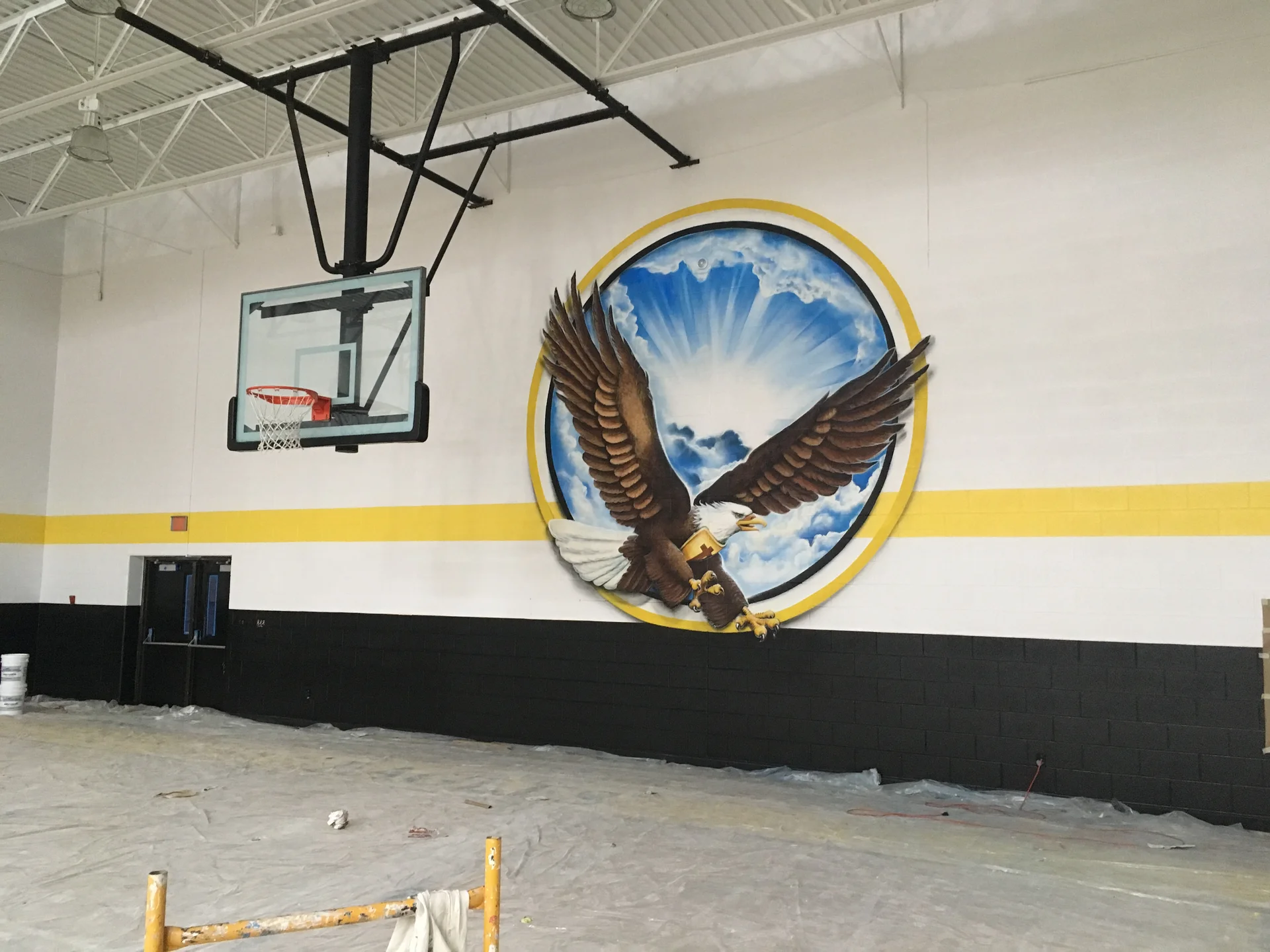 Mid-project — lower black wainscot complete, upper walls in progress around the Eagles mural