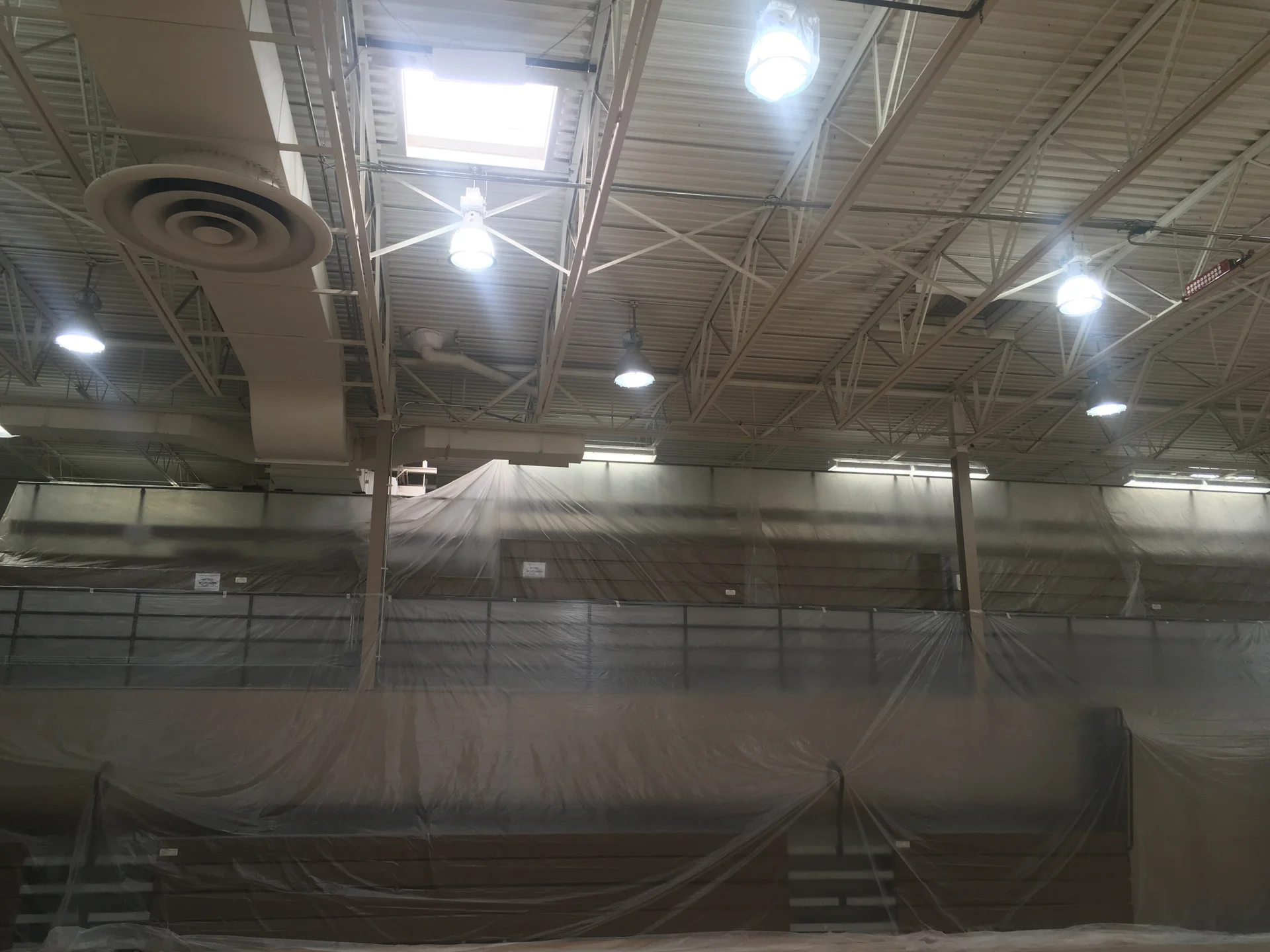 Before — gymnasium at Faith of Davison prior to painting, bleachers covered and floor protected