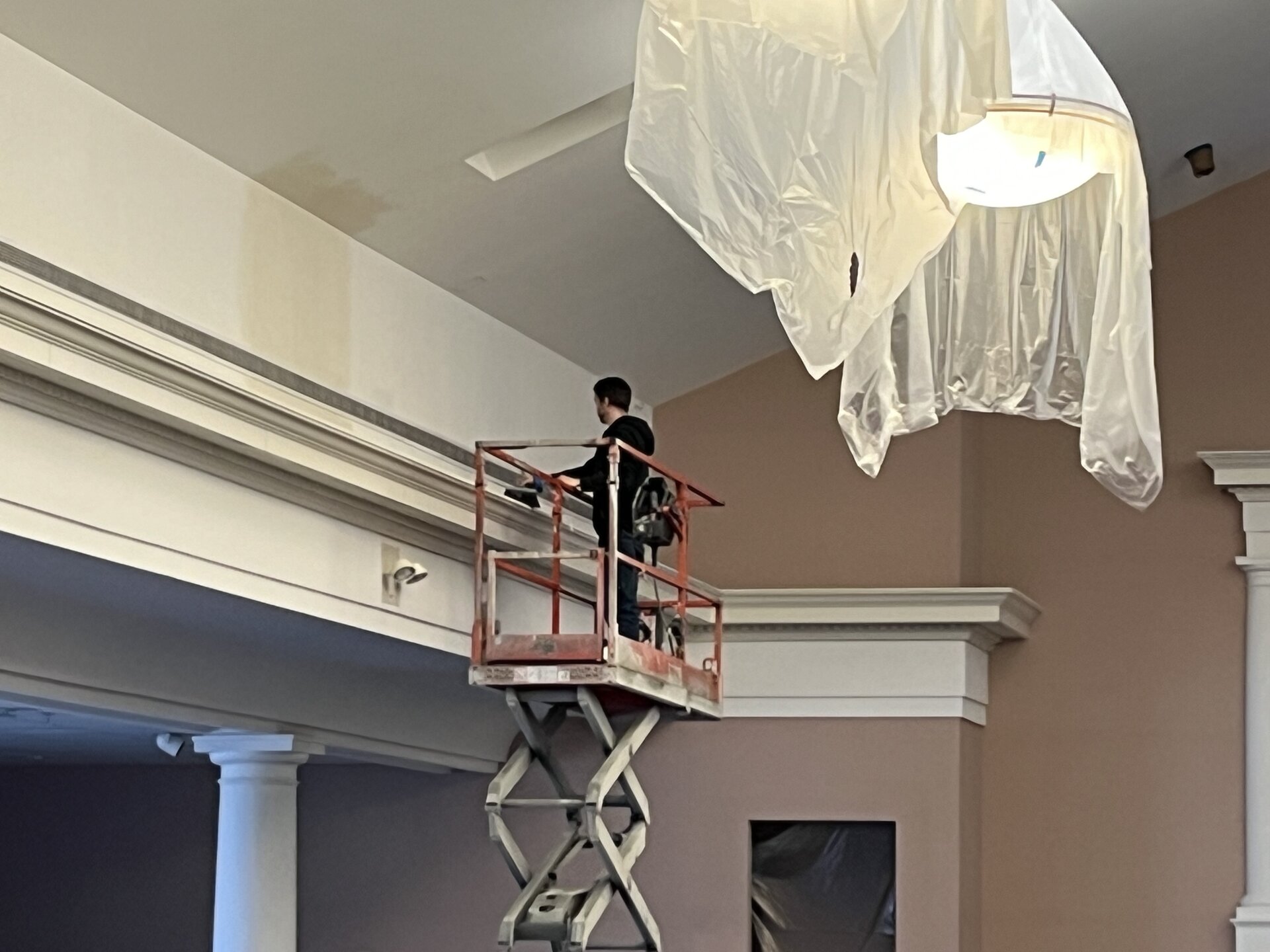 Sanctuary walls being coated — masking and prep work visible