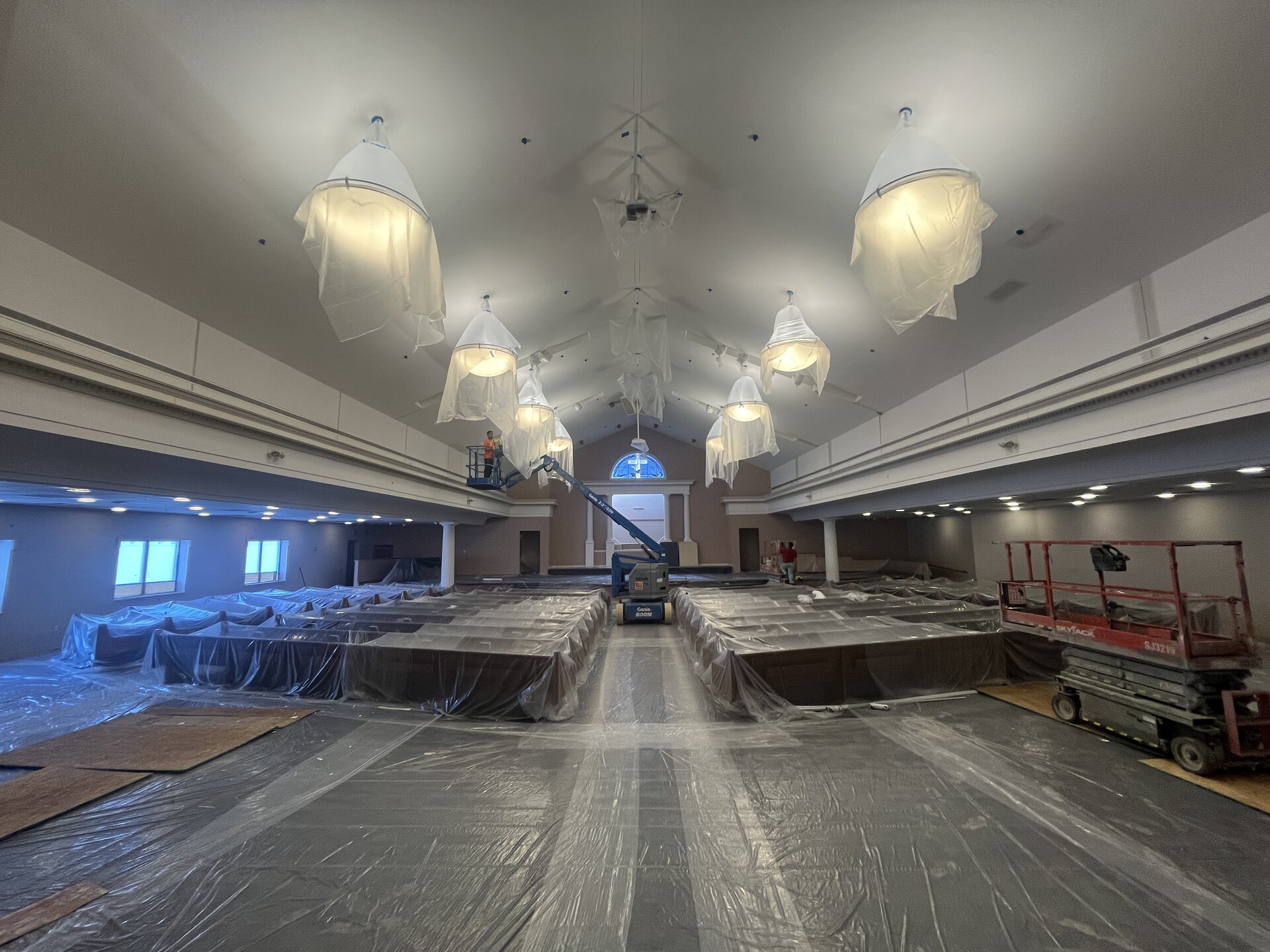 First Baptist Church of Washington auditorium repaint — full sanctuary with crew on boom lift