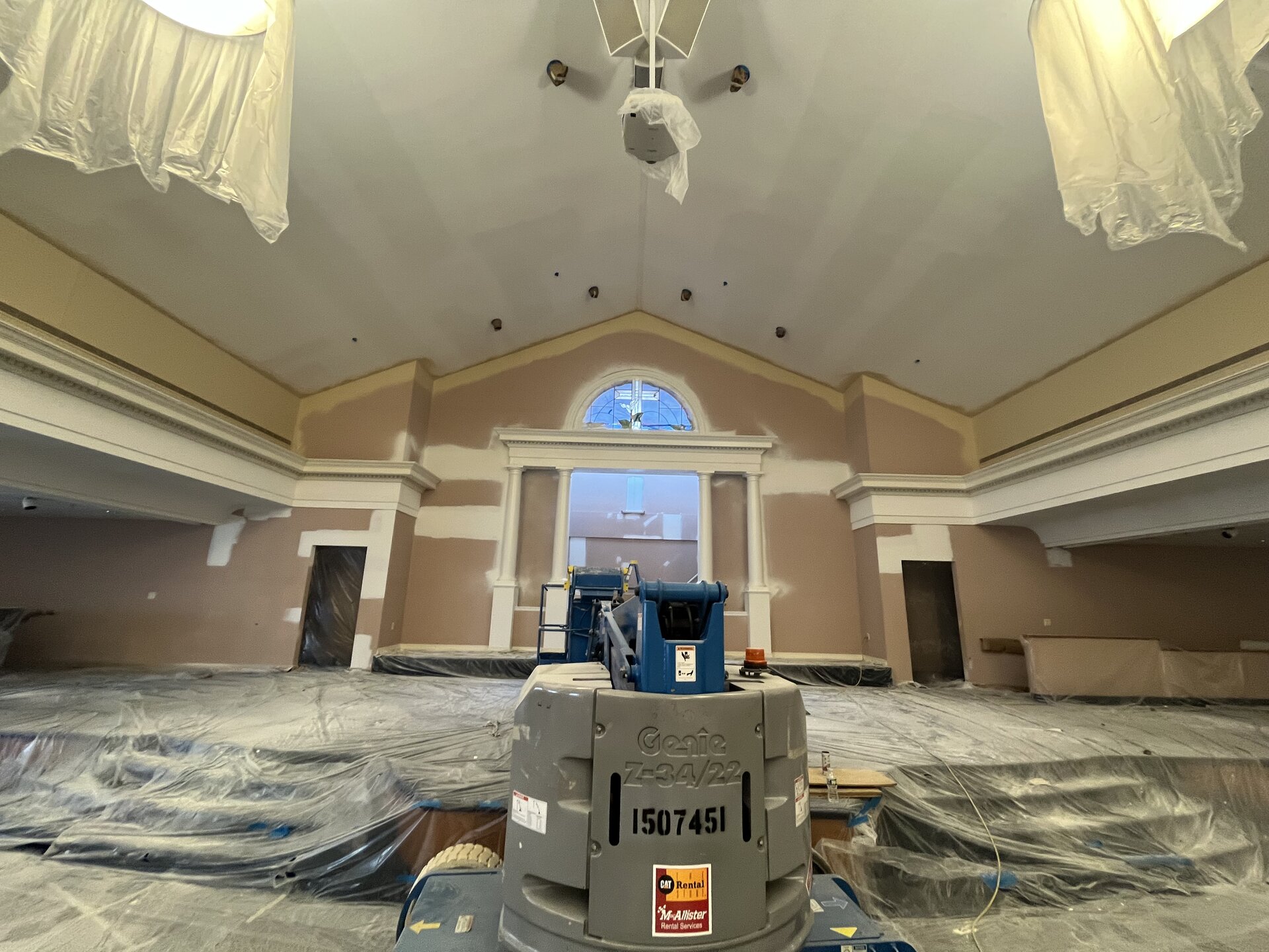 Sanctuary wall painting — crew on lift completing upper sections