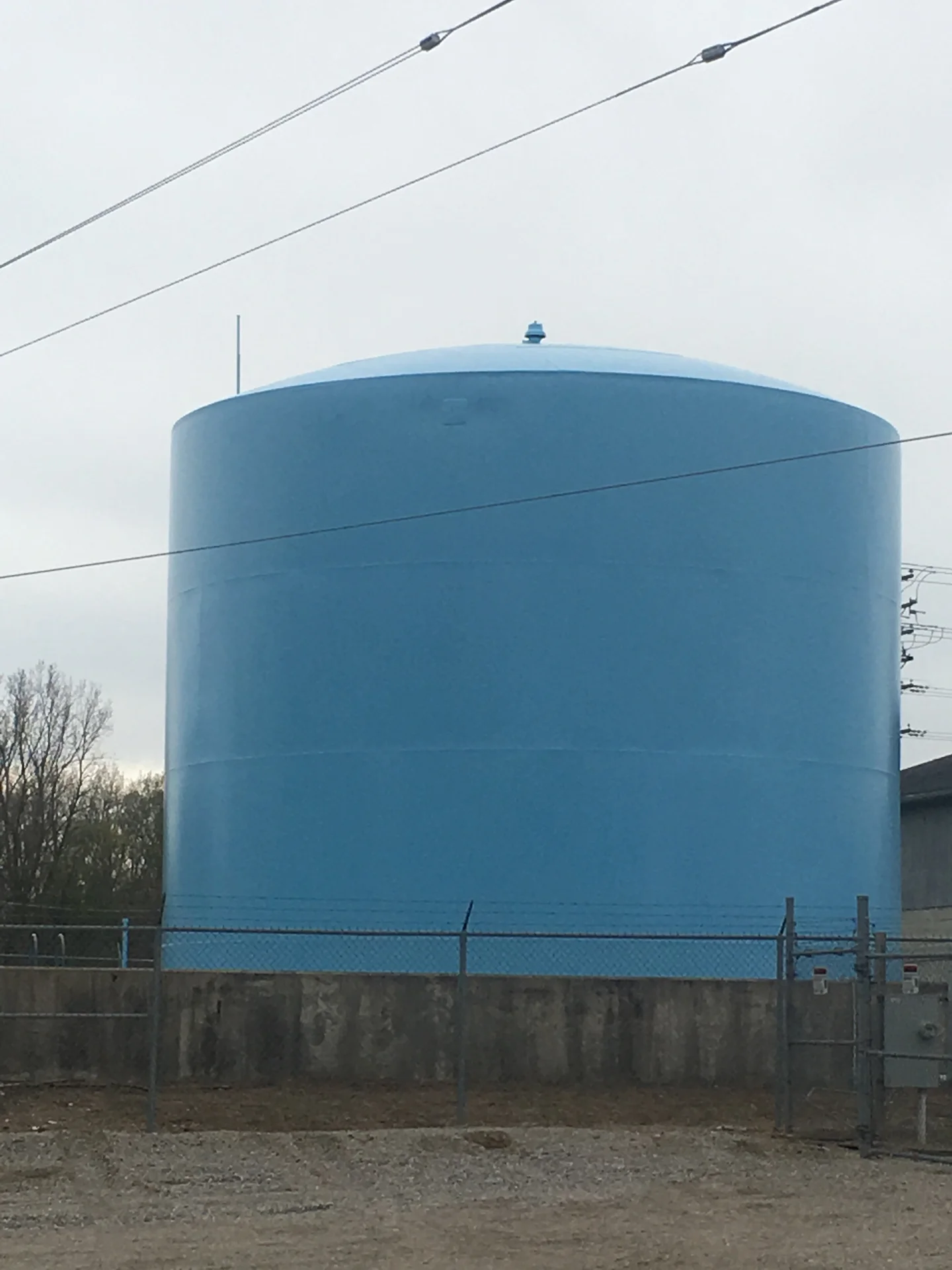 Tank exterior corner view with the facility's electrical substation in the background