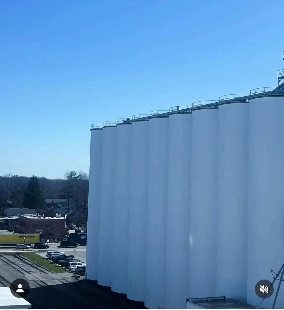 Jiffy tank farm completed — aerial view of the full row of freshly repainted white silos against a blue sky