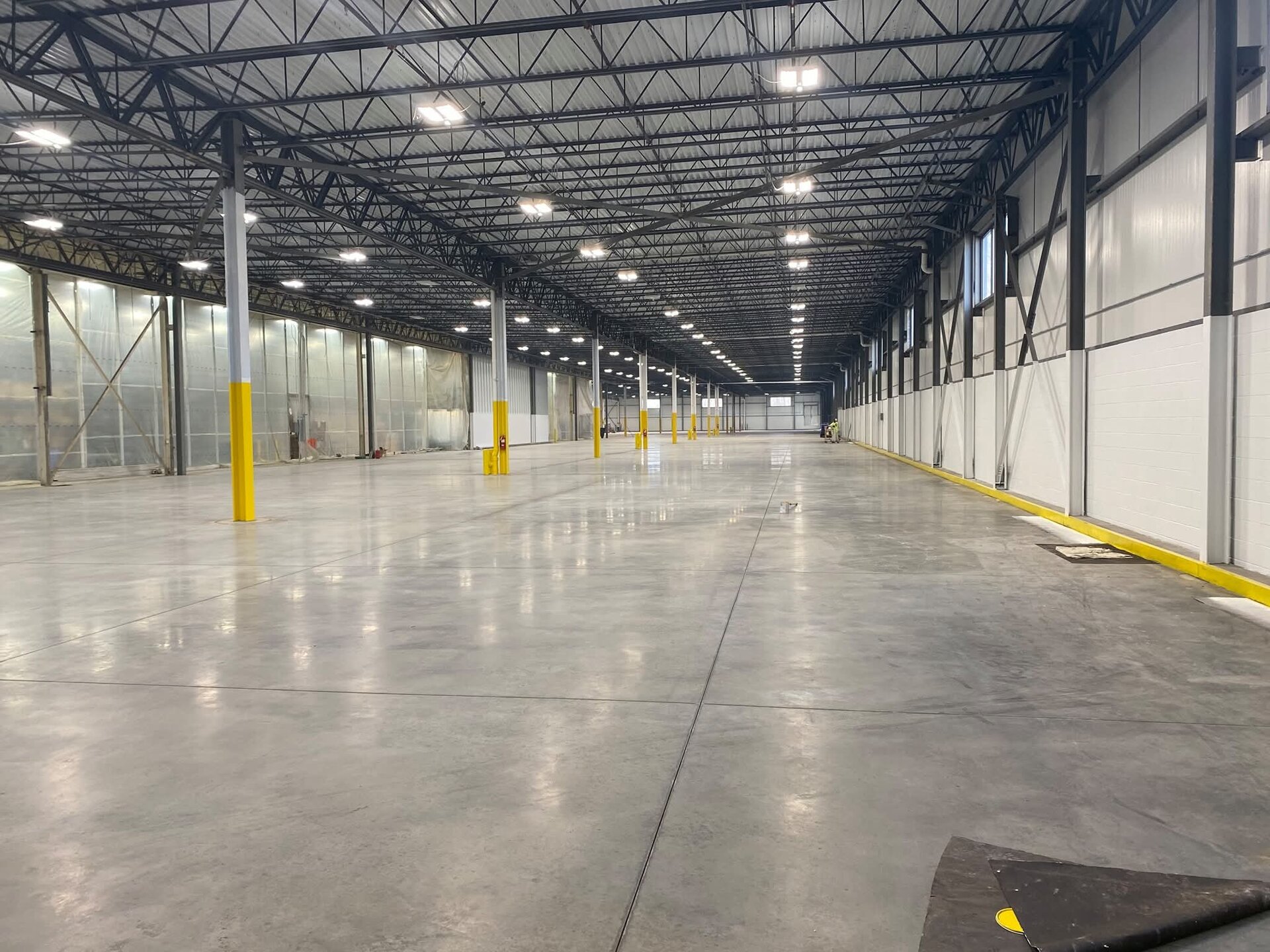Completed OSHA yellow structural column painting — new facility interior