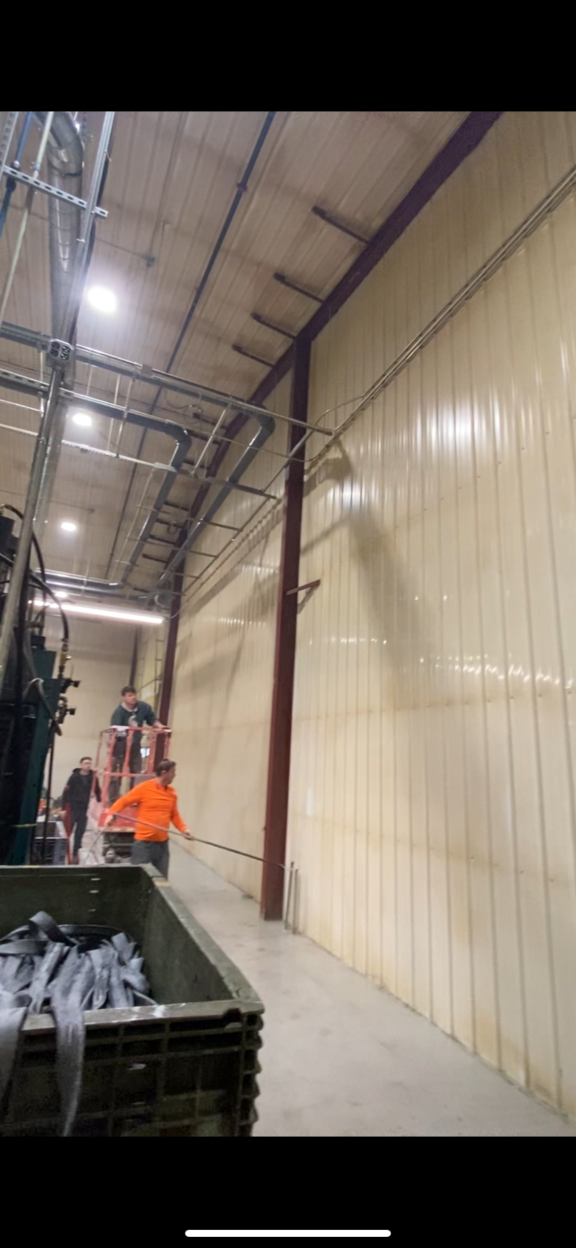 Before — crew pressure washing dirty industrial walls at Vibracoustic