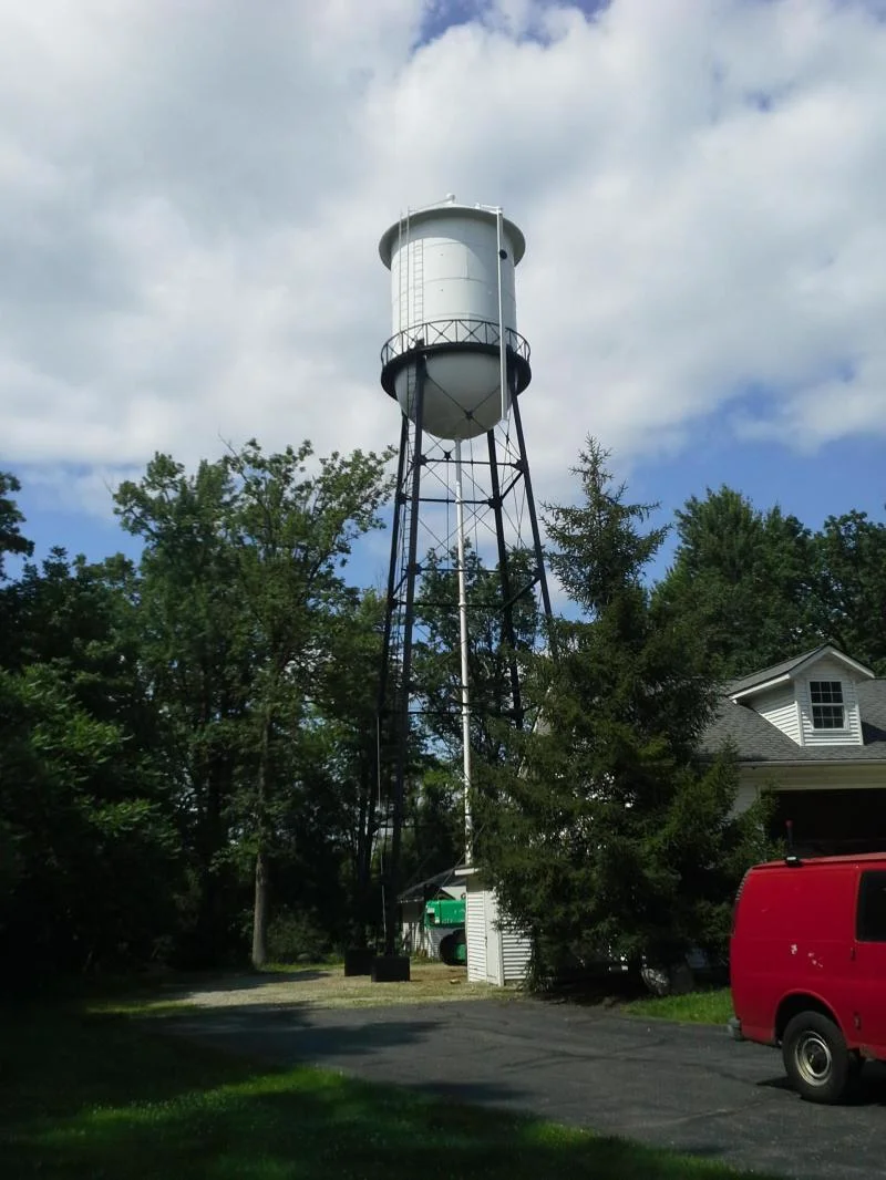 Completed water tower viewed from a distance, freshly painted white
